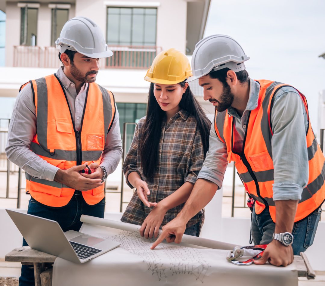 Civil engineer , Construction worker and Architects wearing hardhats and safety vests are working together at construction site ,building ,home in cooperation teamwork concept.